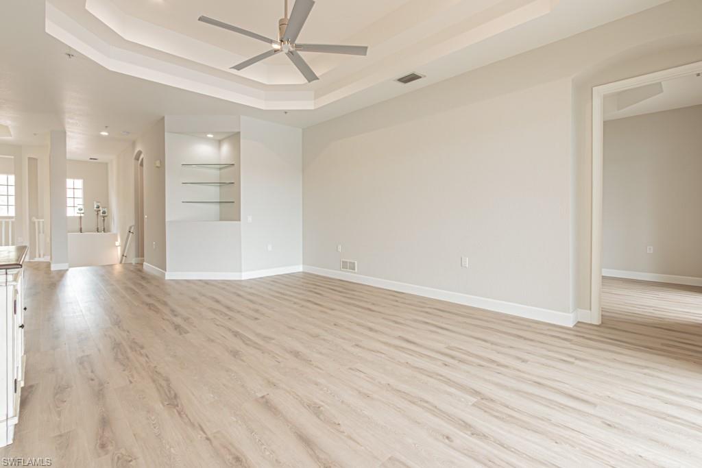 26448 Lucky Stone Road, Unit 202 Bonita Springs, FL 34135 - Photo 11 of 50 a view of an empty room with wooden floor and a ceiling fan