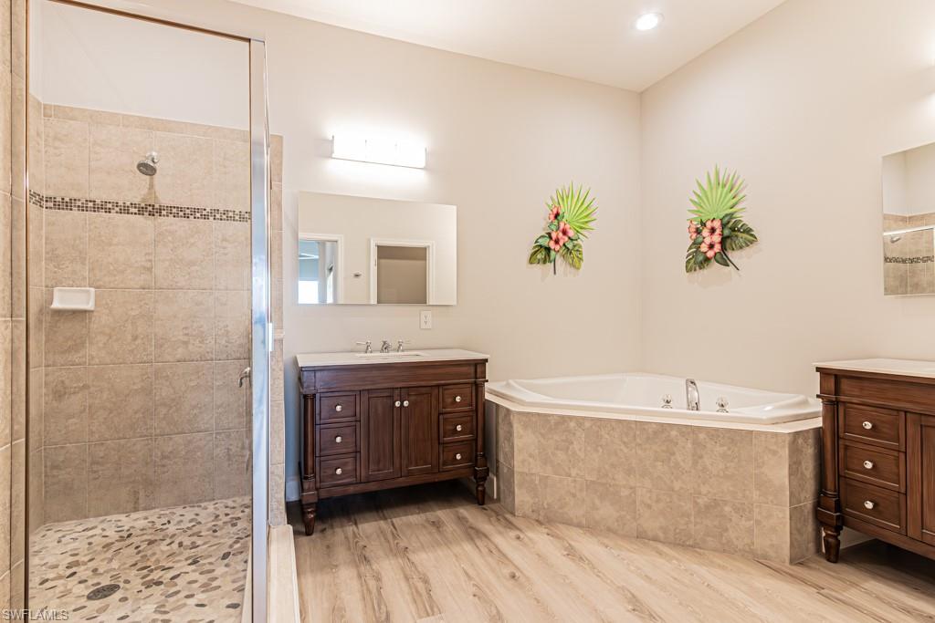 26448 Lucky Stone Road, Unit 202 Bonita Springs, FL 34135 - Photo 28 of 50 a spacious bathroom with a tub sink and mirror