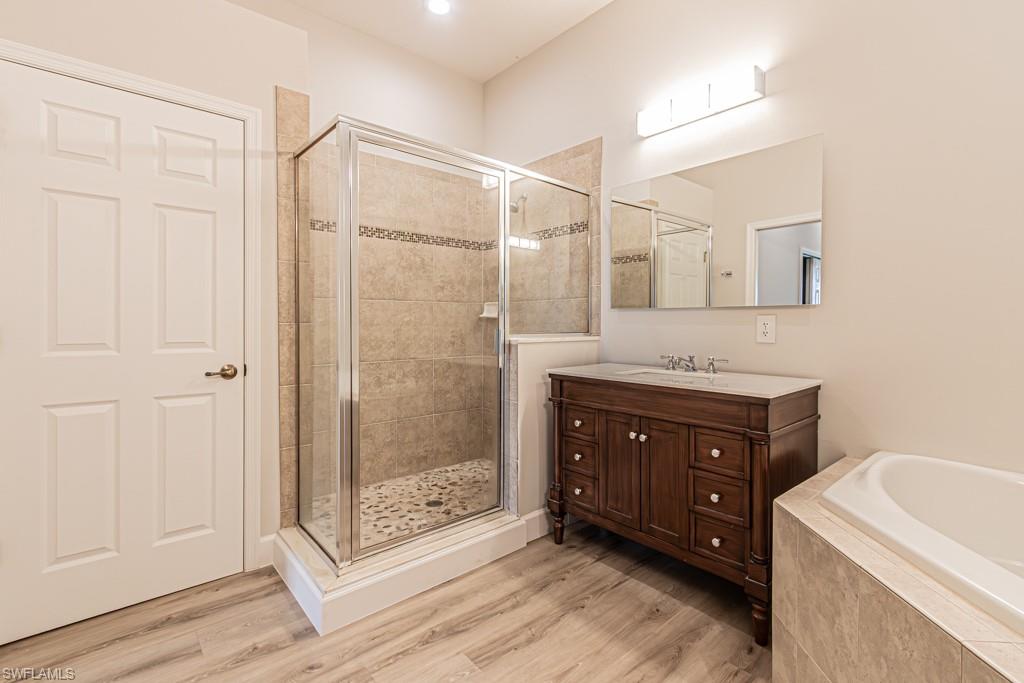 26448 Lucky Stone Road, Unit 202 Bonita Springs, FL 34135 - Photo 31 of 50 a bathroom with a shower sink vanity and mirror