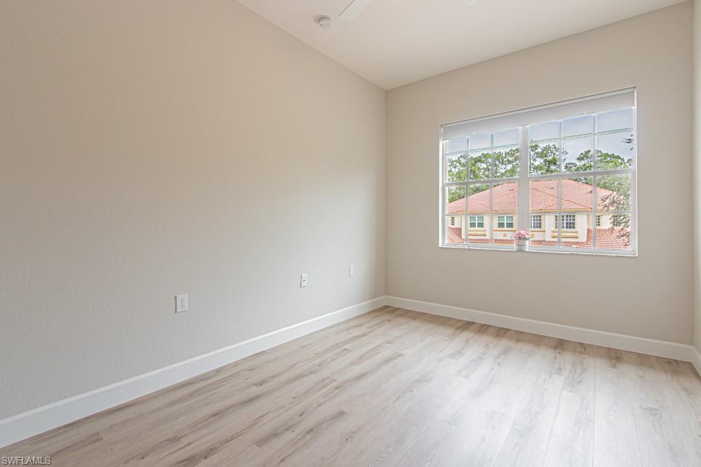 26448 Lucky Stone Road, Unit 202 Bonita Springs, FL 34135 - Photo 37 of 50 a view of an empty room with wooden floor and a window