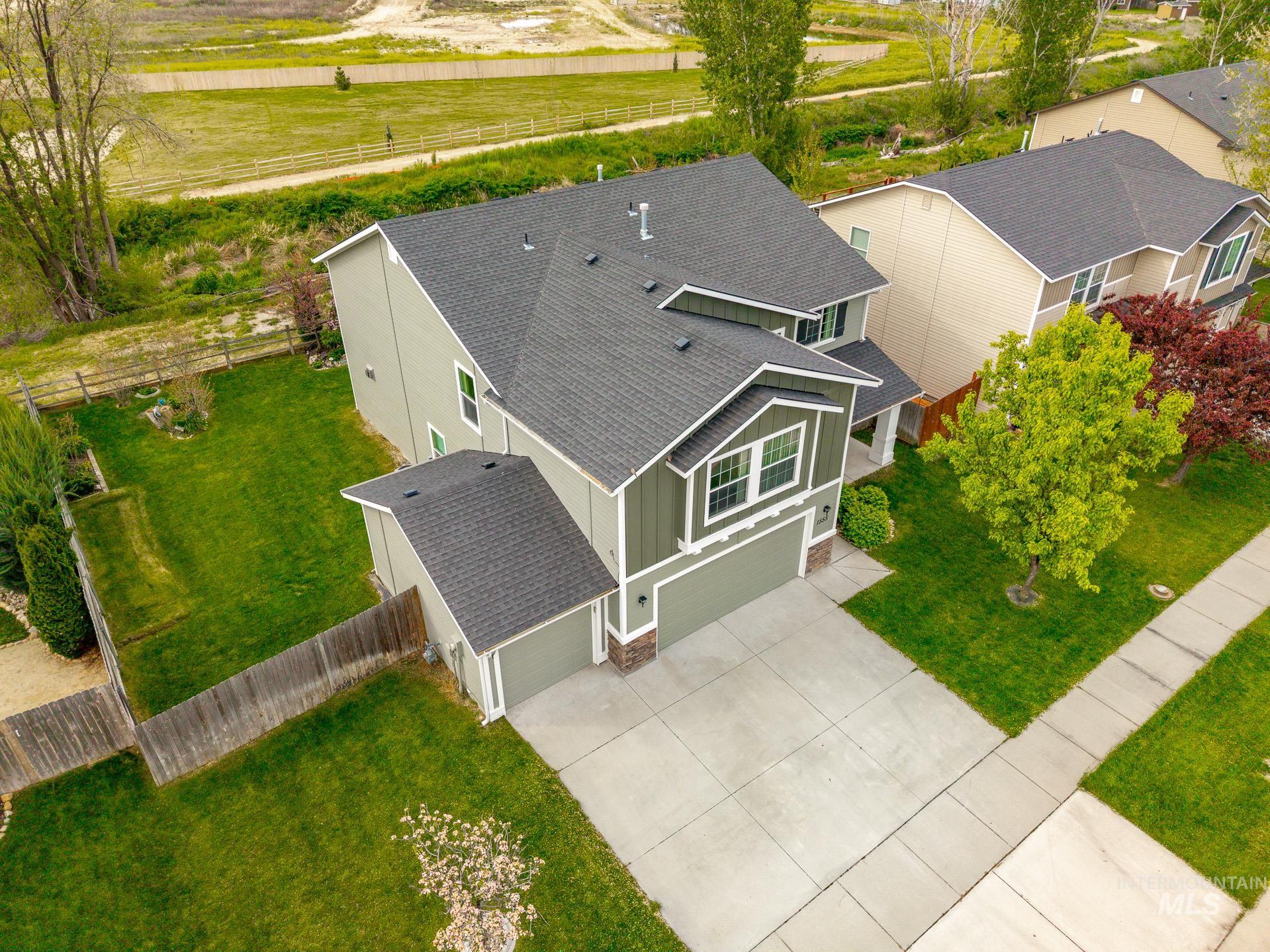 1555 Condor Drive Middleton, ID 83644 - Photo 1 of 50 Contemporary two-story residence featuring a dark asphalt shingle roof, light green siding, and white trim accents