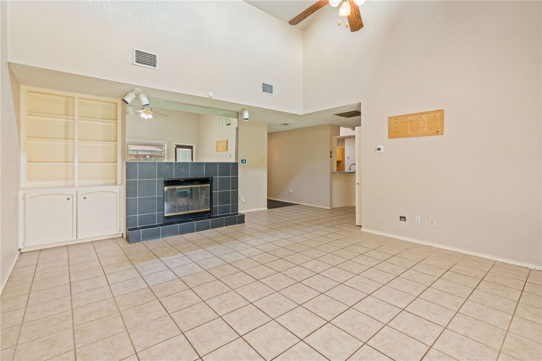 7209 Candy Ridge Road Corpus Christi, TX 78413 - Photo 7 of 24 an empty room with fireplace and chandelier fan