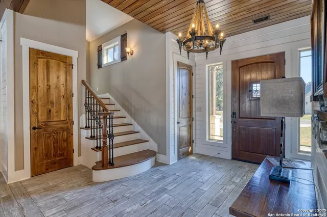 a view of a hallway with wooden floor and staircase