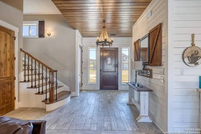 a view of a hallway with entryway wooden floor and chandelier