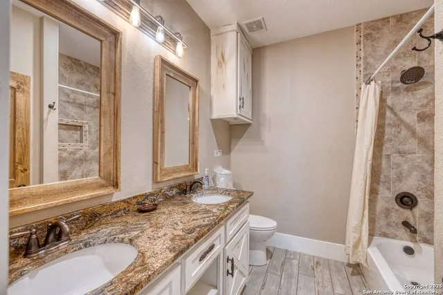 a bathroom with a granite countertop sink toilet and shower