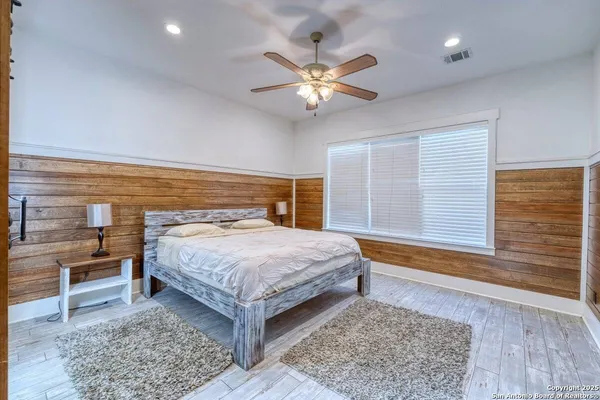 a bedroom with a large bed and a chandelier