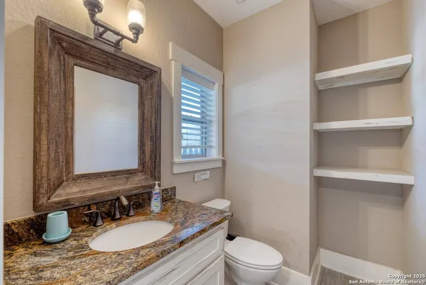 a bathroom with a granite countertop sink toilet a mirror and shower