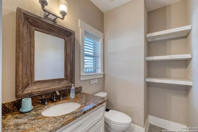 a bathroom with a granite countertop sink toilet a mirror and shower