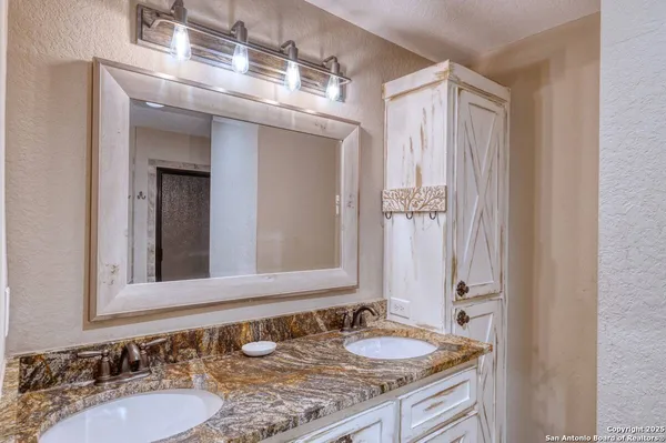 a bathroom with a granite countertop sink and a mirror