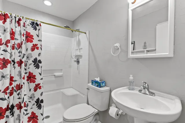 a bathroom with a sink a toilet and shower curtain