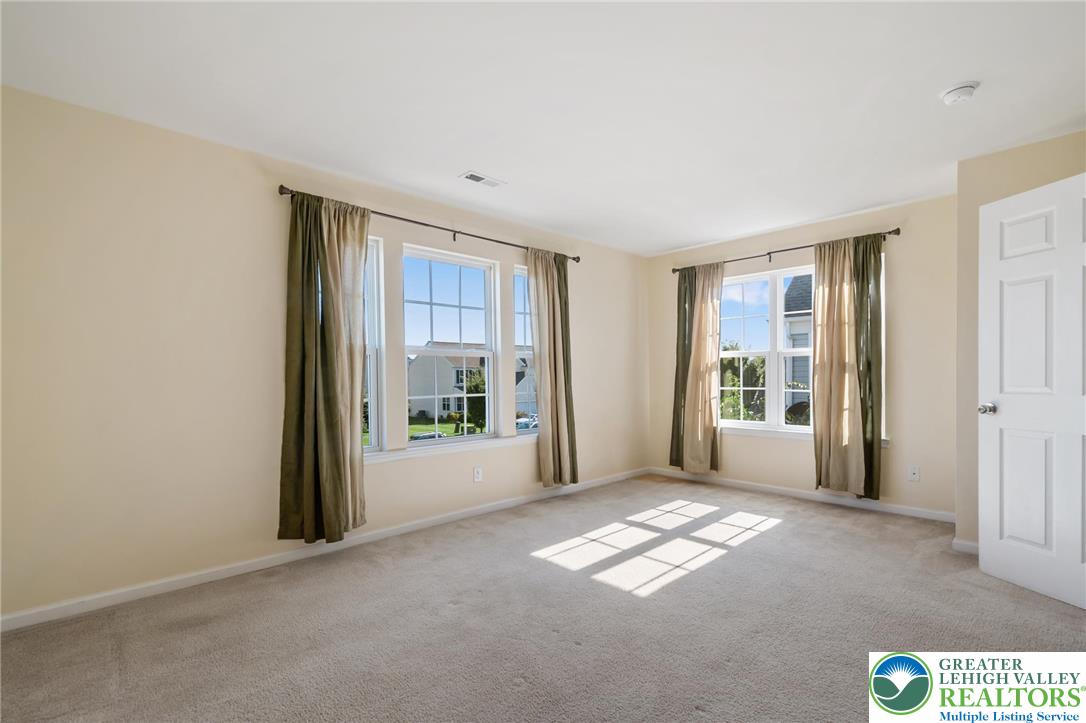 8455 Starling Road Breinigsville, PA 18031 - Photo 18 of 24 Sun-drenched interiors await in this well-appointed bed room , featuring abundant natural light and soft carpeting.