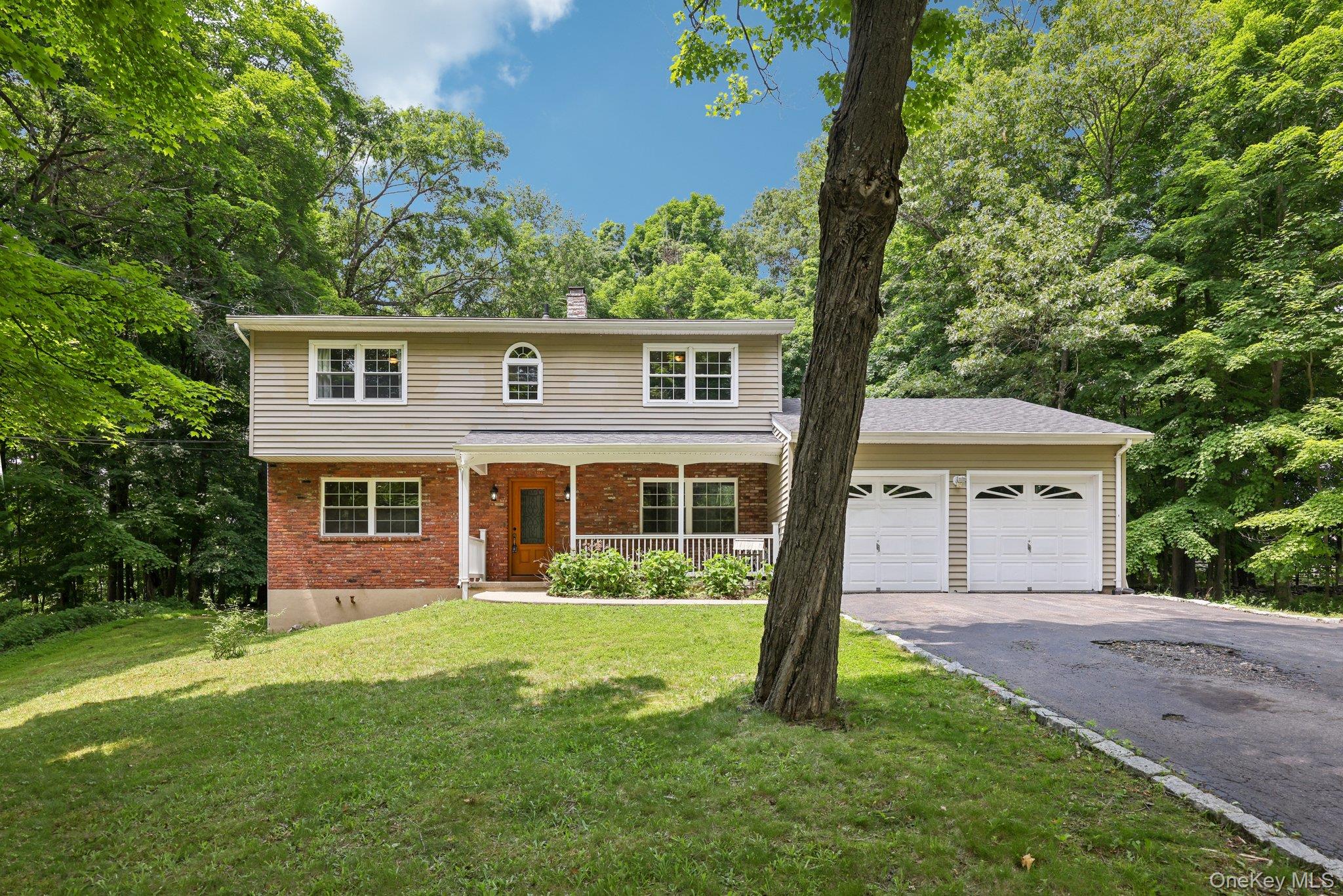 a front view of a house with yard and green space