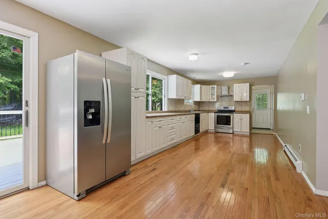 a kitchen with stainless steel appliances granite countertop a refrigerator and a stove top oven