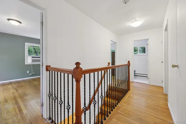 a view of a hallway with wooden floor and stairs