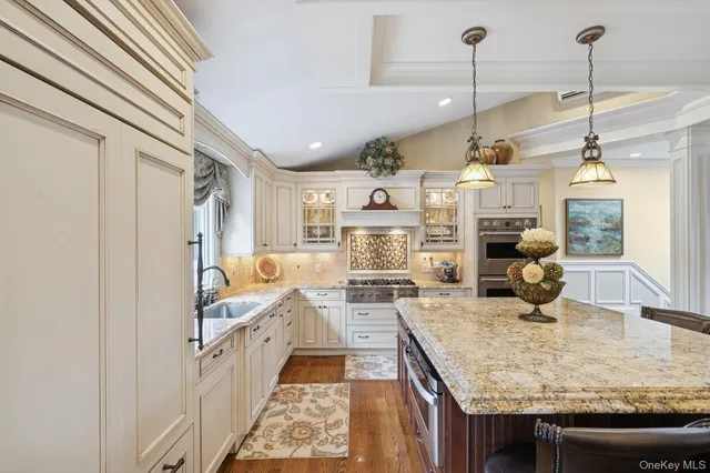 a kitchen with stainless steel appliances granite countertop a sink refrigerator and cabinets