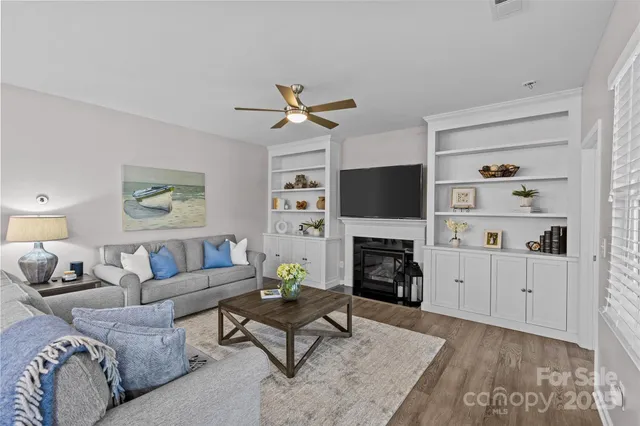 a living room with furniture a fireplace and a flat screen tv
