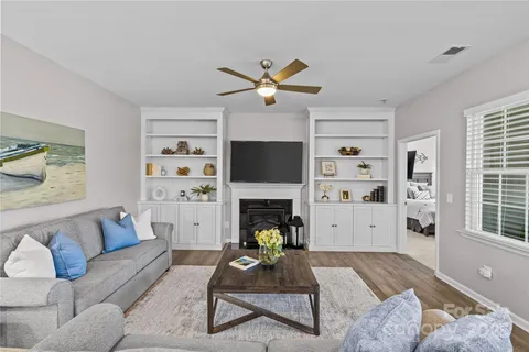 a living room with furniture a fireplace and a flat screen tv