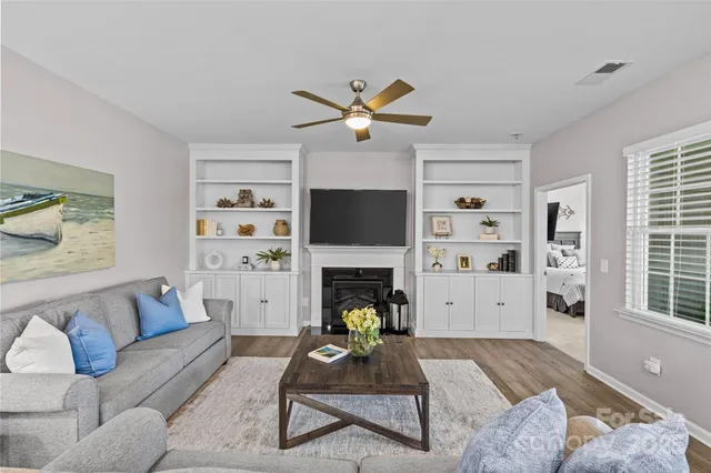 a living room with furniture a fireplace and a flat screen tv
