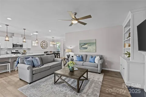 a living room with furniture kitchen view and a window