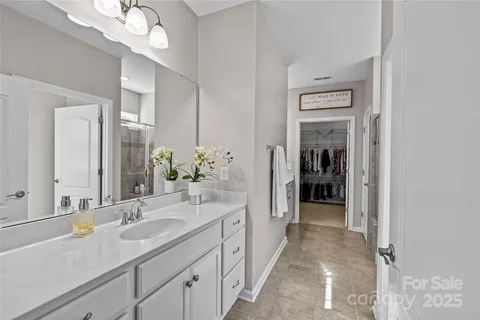 a spacious en suite bathroom with a sink and a mirror