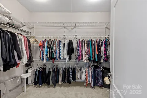a view of walk in closet with clothes
