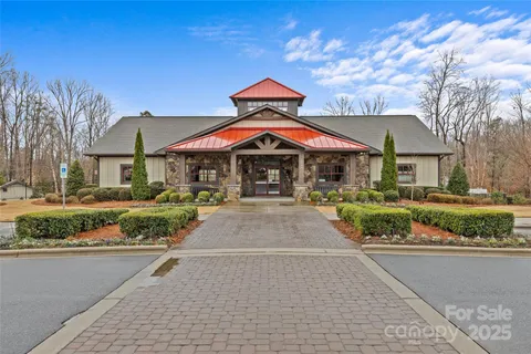 a front view of a house with a yard and potted plants
