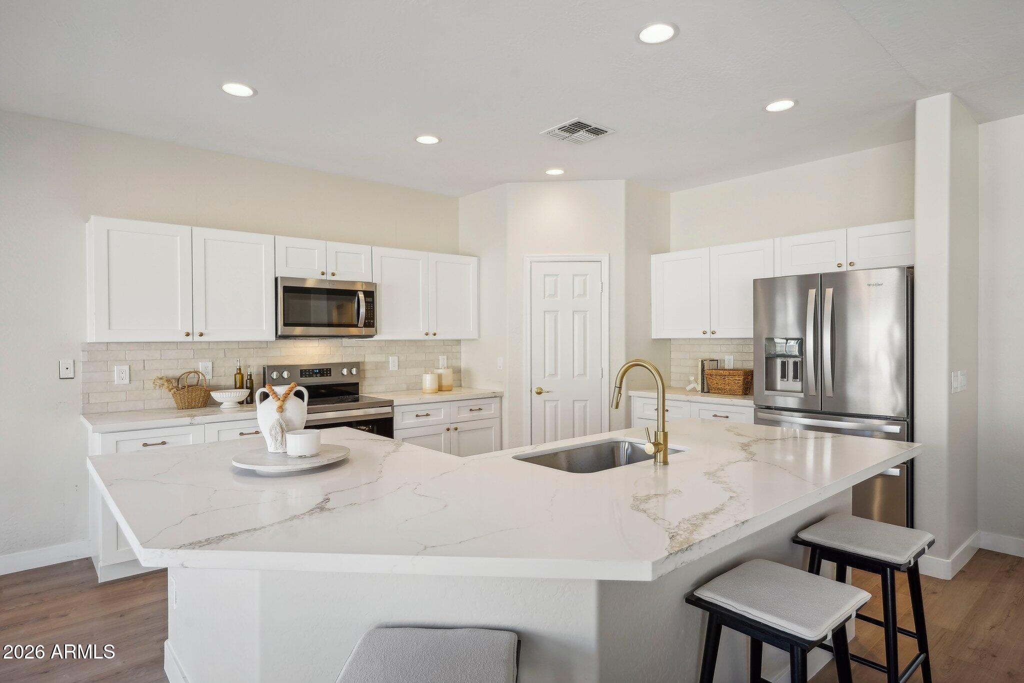 12806 West Charter Oak Road El Mirage, AZ 85335 - Photo 10 of 36 a kitchen with kitchen island a appliances a sink and a refrigerator