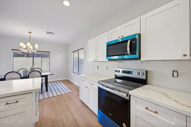 a kitchen with a sink a microwave a refrigerator and cabinets