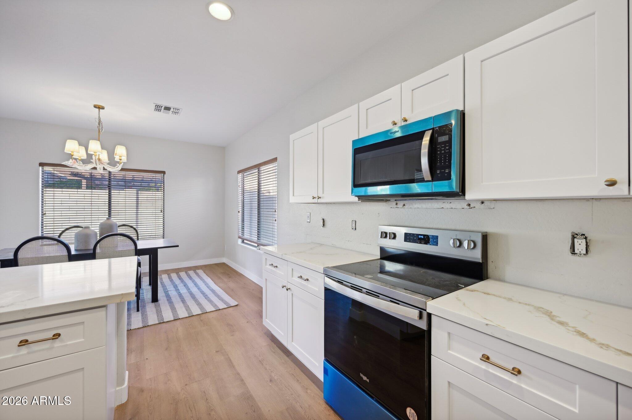 12806 West Charter Oak Road El Mirage, AZ 85335 - Photo 13 of 36 a kitchen with a sink stove and microwave