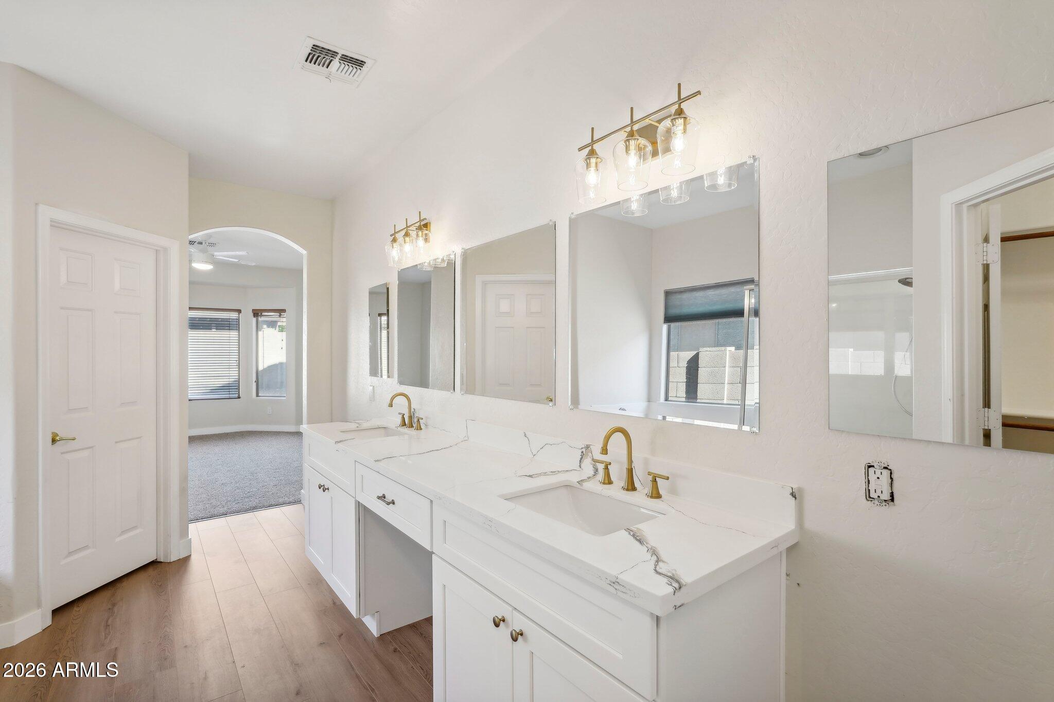 12806 West Charter Oak Road El Mirage, AZ 85335 - Photo 14 of 36 a bathroom with a sink vanity granite tub and a mirror