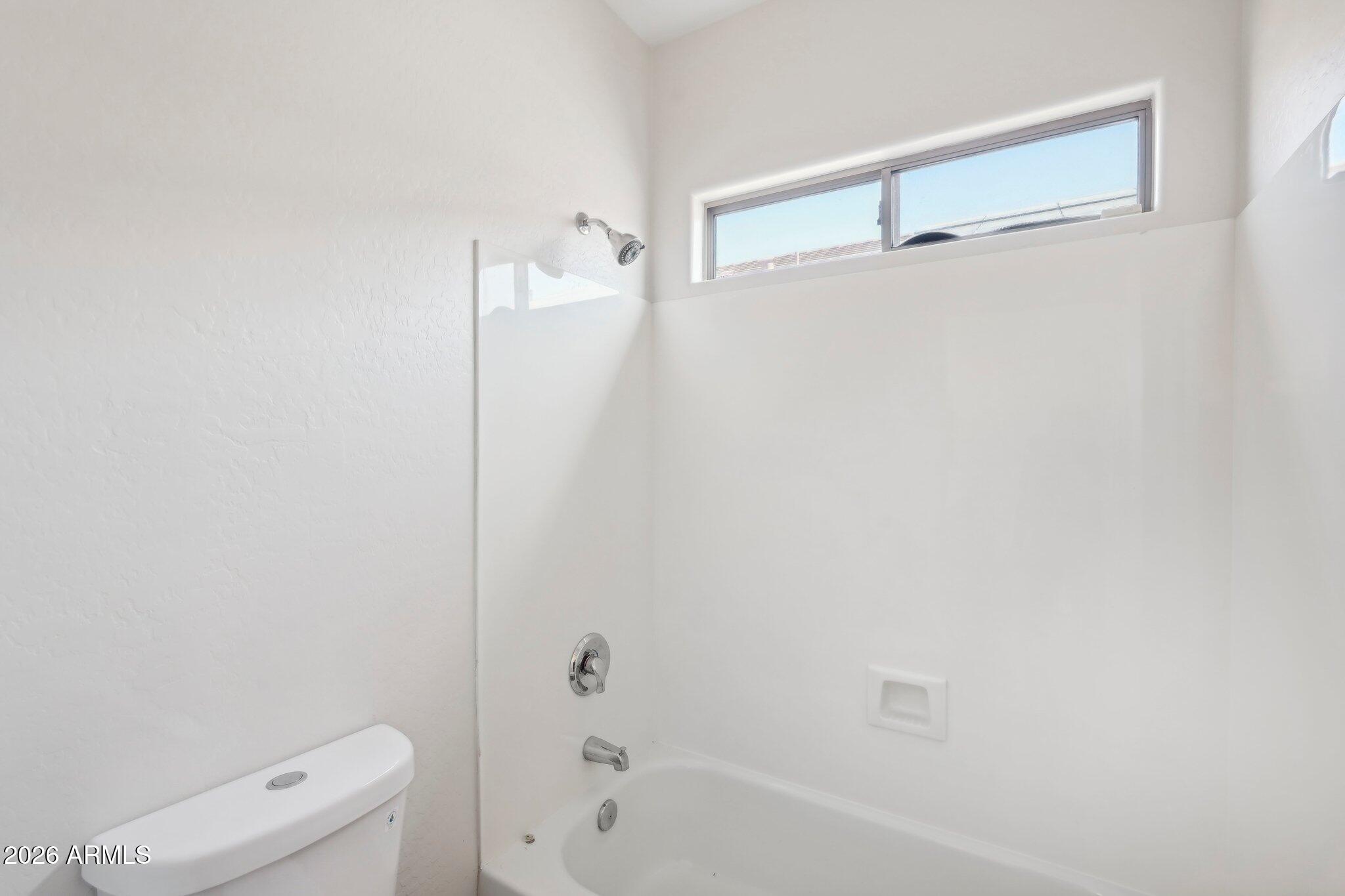 12806 West Charter Oak Road El Mirage, AZ 85335 - Photo 26 of 36 a bathroom with a shower and a toilet