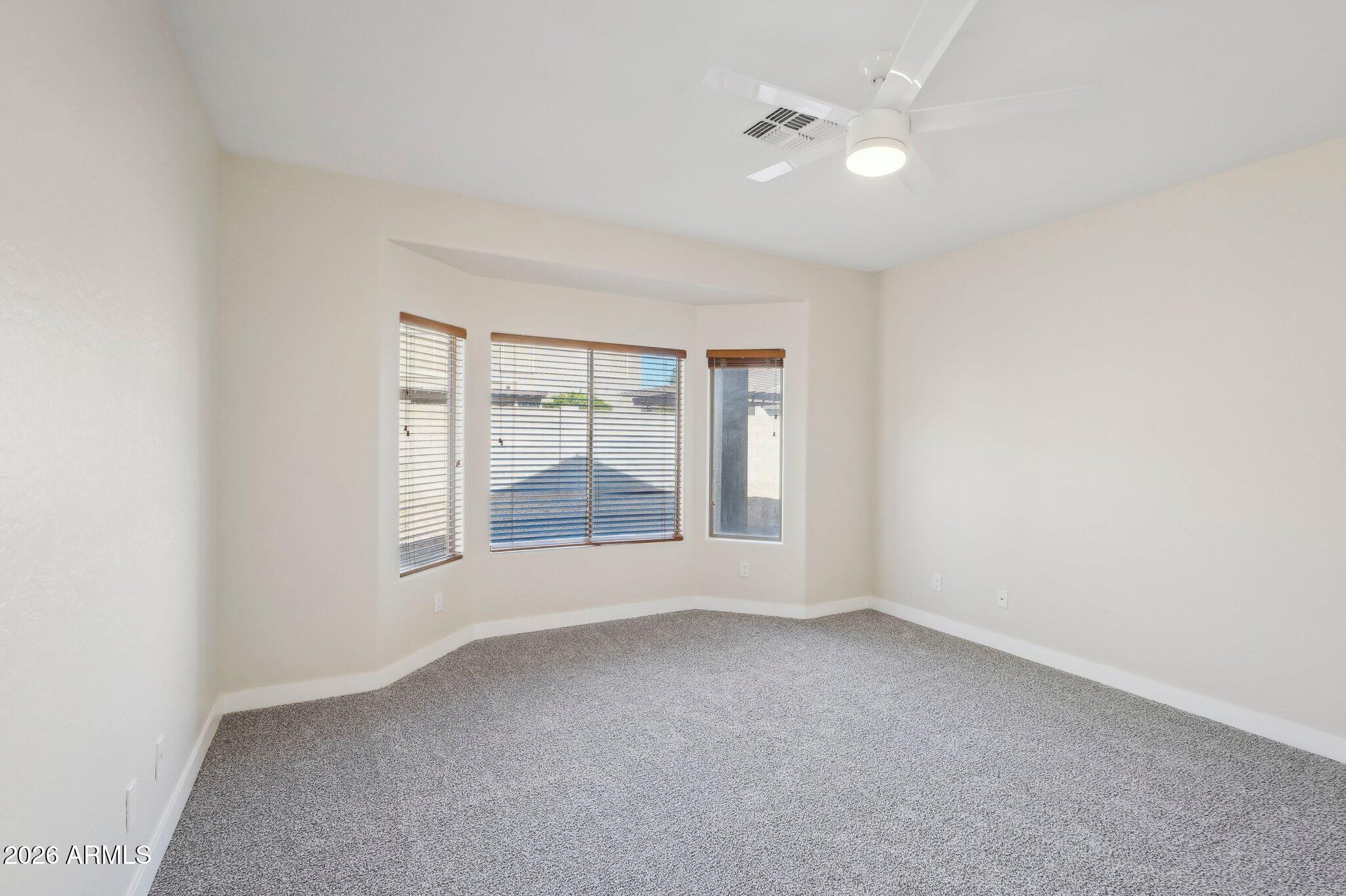 12806 West Charter Oak Road El Mirage, AZ 85335 - Photo 33 of 36 an empty room with a window and a fan