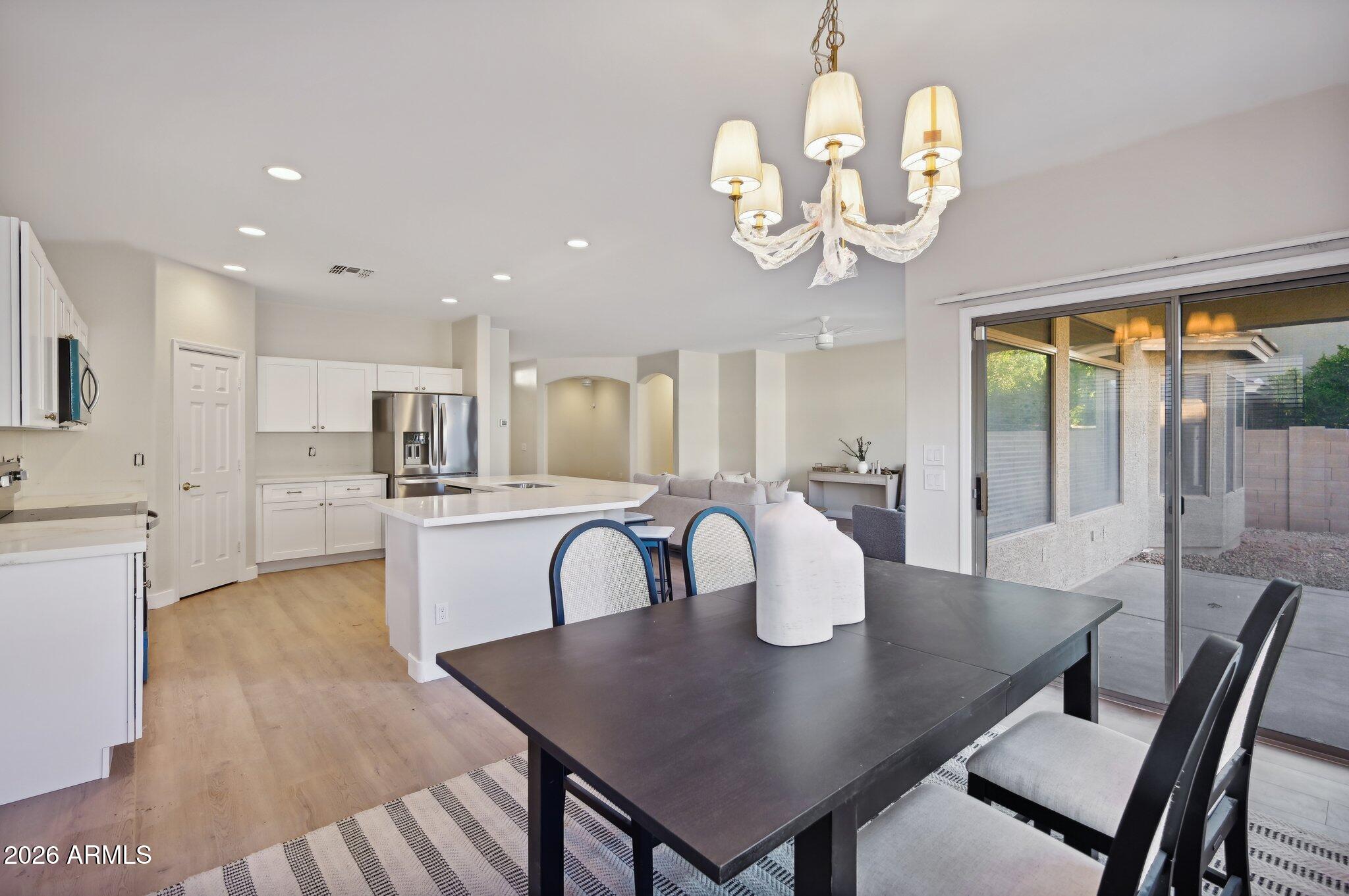 12806 West Charter Oak Road El Mirage, AZ 85335 - Photo 9 of 36 a view of a dining room with furniture a chandelier and wooden floor