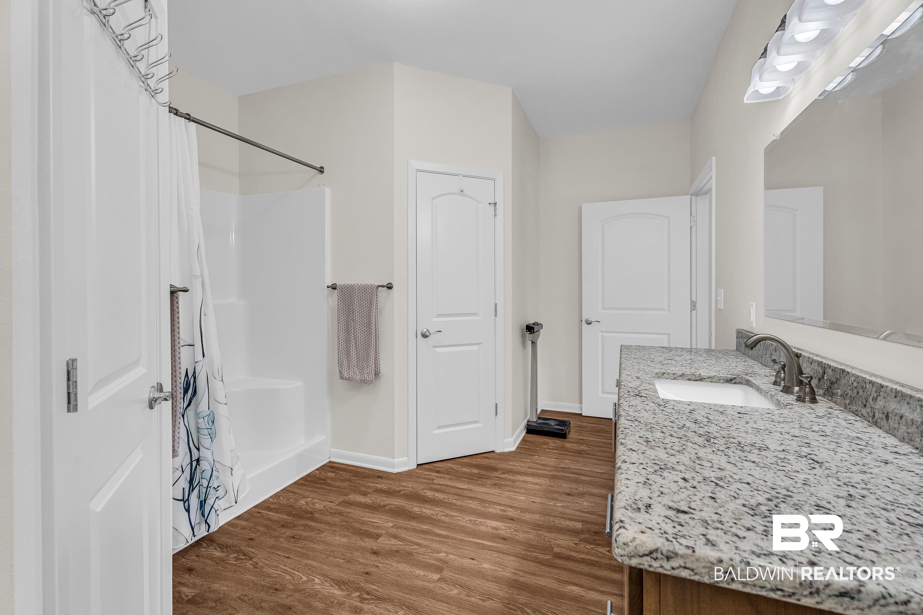 18255 Cactus Court Elberta, AL 36530 - Photo 27 of 53 Full bath featuring vanity, dark wood-style flooring, and shower / tub combo