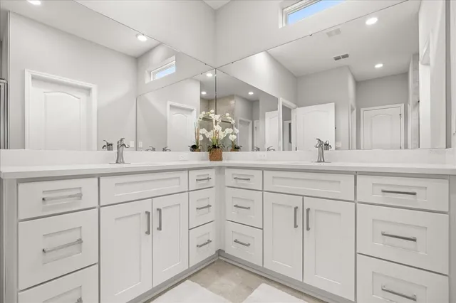 a bathroom with double sink and a mirror