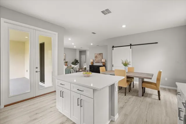 a view of kitchen island wooden floor dining table and chairs