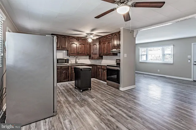 a kitchen with stainless steel appliances granite countertop a sink a stove and a refrigerator