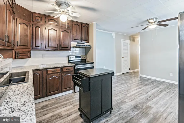 a kitchen with stainless steel appliances granite countertop a stove a sink and a refrigerator