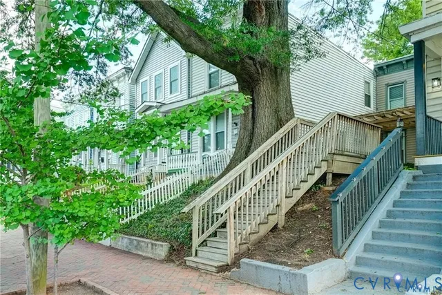 a view of house with wooden stairs and a small yard