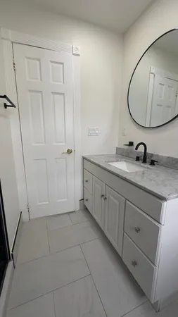 a bathroom with a granite countertop sink a mirror and a vanity