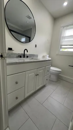 a bathroom with a toilet a sink and mirror
