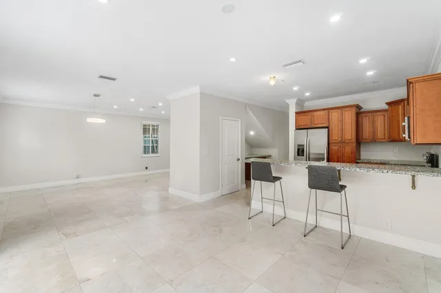 a view of kitchen with kitchen island stainless steel appliances refrigerator stove dining table and chairs