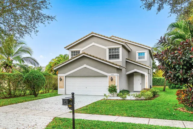 a front view of a house with a yard and garage