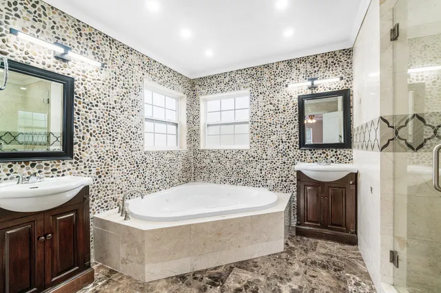 a bathroom with a sink a bathtub a mirror a vanity and a shower