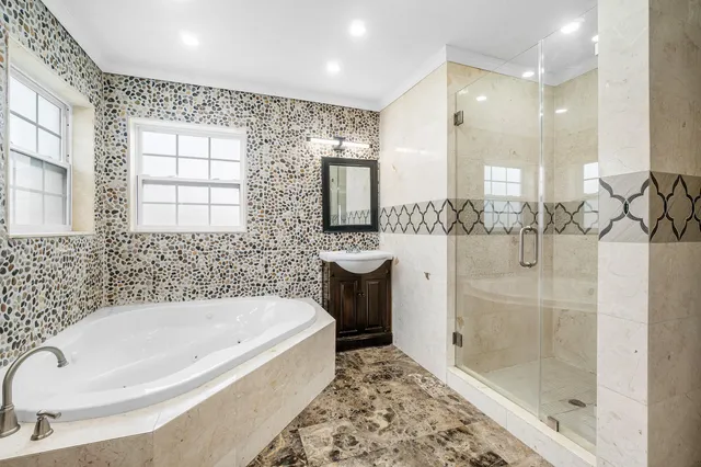 a bathroom with a tub sink and mirror