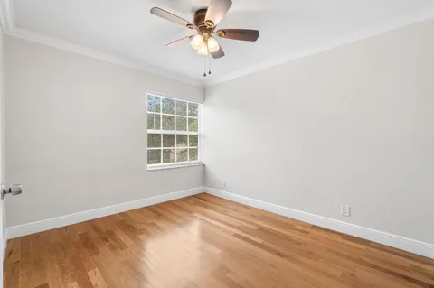 a view of a big room with windows and chandelier fan