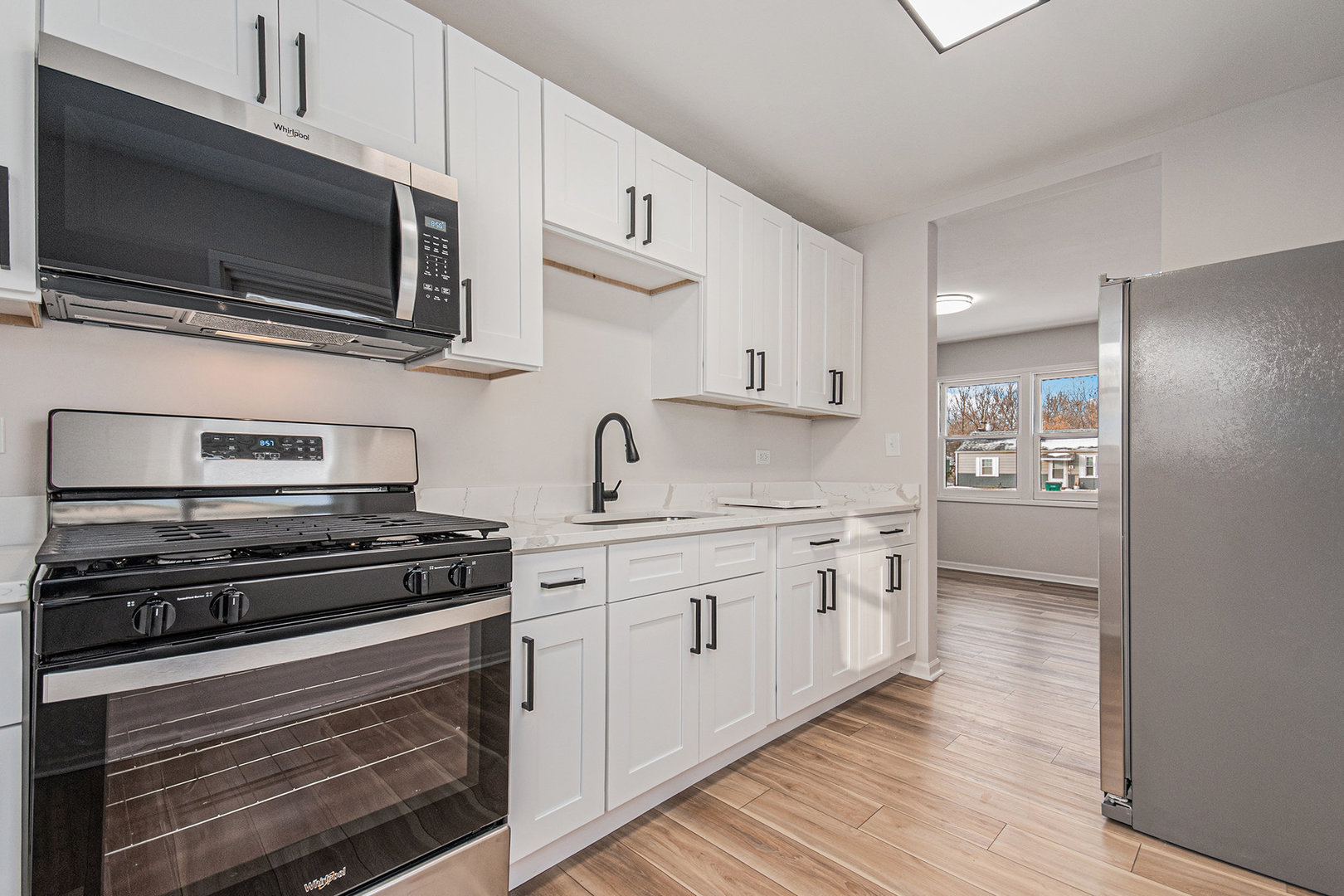 512 Sehring Street Joliet, IL 60436 - Photo 6 of 15 a kitchen with cabinets stainless steel appliances and wooden floor