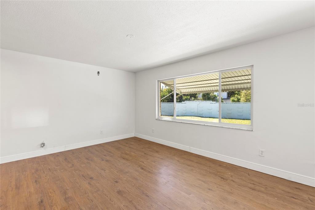 250 Rosery Road Northwest, Unit 314 Largo, FL 33770 - Photo 5 of 16 an empty room with wooden floor and a window