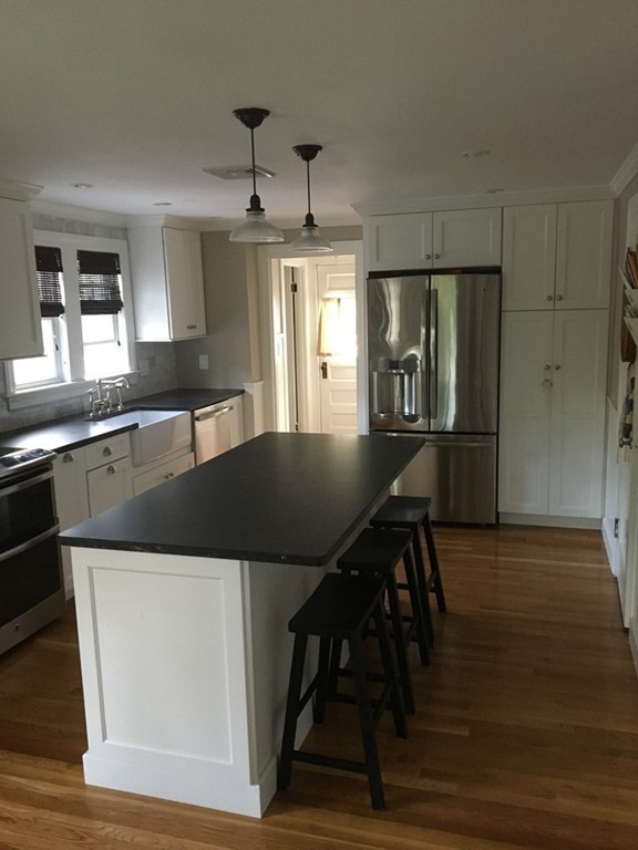 4 Latin Road Boston, MA 02132 - Photo 3 of 16 a kitchen with a table chairs and wooden floor