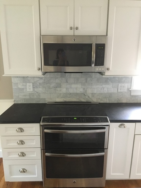 4 Latin Road Boston, MA 02132 - Photo 6 of 16 a kitchen with white cabinets and appliances